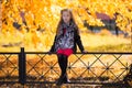 In autumn park walking little beautiful fashionable girl