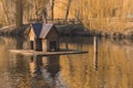 Autumn peaceful park outdoor scenery nature view of pond waters and wooden bird cottage landscaping object September season Royalty Free Stock Photo