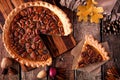 Pecan pie with slice removed, table scene over wood