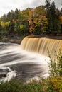 Autumn photo of Upper Tahquamenon Falls in Michigan with water cascading into the river below surrounded by evergreen trees and Royalty Free Stock Photo