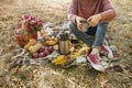 Autumn picnic in the park. The girl holds a cup of tea in her hands. Basket with flowers on a blanket in yellow autumn leaves. Royalty Free Stock Photo