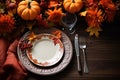 Autumn place setting with fall leaves, napkin and pumpkins. Thanksgiving autumn place setting with cutlery and arrangement of fall