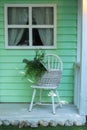 Autumn porch home. Cozy terrace with chair and basket with flowers. Decorations in summer patio for relax. Stylish fall decor on f Royalty Free Stock Photo