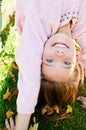 Autumn portrait of adorable smiling little girl child standing upside down on grass and having fun Royalty Free Stock Photo