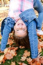 Autumn portrait of adorable smiling little girl child standing upside down on grass Royalty Free Stock Photo