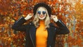 Autumn portrait of beautiful happy smiling young woman wearing black round hat, sunglasses and coat jacket in the park on leaves Royalty Free Stock Photo