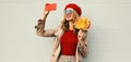 Autumn portrait of beautiful smiling woman taking selfie picture by phone with yellow maple leaves wearing red french beret Royalty Free Stock Photo