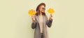 Autumn portrait of beautiful smiling young woman with yellow maple leaves wearing round hat, coat on white background Royalty Free Stock Photo