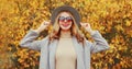 Autumn portrait of beautiful young woman wearing gray coat, round hat posing over yellow leaves Royalty Free Stock Photo