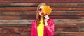 Autumn portrait of beautiful young woman with yellow maple leaves blowing her lips with lipstick wearing red heart shaped Royalty Free Stock Photo