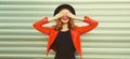 Autumn portrait of cheerful happy laughing woman covering her face with her hands wearing black round hat, red leather jacket on Royalty Free Stock Photo