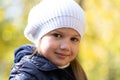 Autumn portrait of cute little blond girl in white hat. Beautiful smiling child having fun outdoors on a warm fall day Royalty Free Stock Photo