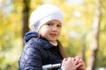 Autumn portrait of cute little blond girl in white hat. Beautiful smiling child having fun outdoors on a warm fall day Royalty Free Stock Photo