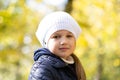 Autumn portrait of cute little blond girl in white hat. Beautiful smiling child having fun outdoors on a warm fall day Royalty Free Stock Photo