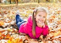 Autumn portrait of cute little girl lying in maple leaves Royalty Free Stock Photo