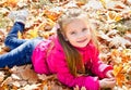 Autumn portrait of cute little girl lying in maple leaves Royalty Free Stock Photo