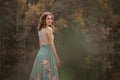 A girl is dancing on a wooden bridge against the backdrop of a forest lake. Royalty Free Stock Photo