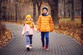 Autumn portrait of happy brother and sister walking the road in sunny park Royalty Free Stock Photo