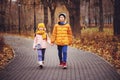 Autumn portrait of happy brother and sister walking the road in sunny park Royalty Free Stock Photo