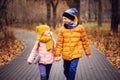 Autumn portrait of happy brother and sister walking the road in sunny park Royalty Free Stock Photo