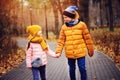 Autumn portrait of happy brother and sister walking the road in sunny park Royalty Free Stock Photo