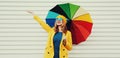 Autumn portrait happy cheerful smiling young woman with colorful umbrella wearing a yellow coat and beret on a white background Royalty Free Stock Photo