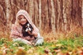 Autumn portrait of happy kid girl playing with her spaniel dog in the garden Royalty Free Stock Photo