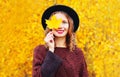 Autumn portrait smiling woman hides her eye maple yellow leaves