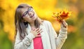 Autumn. Portrait of a smiling young girl who is holding in her hand a bouquet of autumn maple leaves.