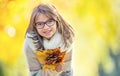 Autumn. Portrait of a smiling young girl who is holding in her hand a bouquet of autumn maple leaves.