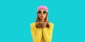 Autumn portrait of stylish beautiful young woman model blowing her lips sends sweet kiss wearing colorful hat, yellow sunglasses Royalty Free Stock Photo