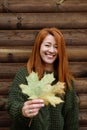 Autumn portrait young adult woman in sweater with maple leaf Royalty Free Stock Photo