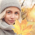 Autumn portrait of young woman with autumnal maple leaf outdoors Royalty Free Stock Photo