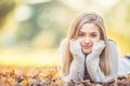 Autumn portrait of young woman lying on maple leaves in park Royalty Free Stock Photo
