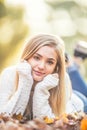 Autumn portrait of young woman lying on maple leaves in park Royalty Free Stock Photo