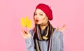 Autumn portrait young woman model with yellow maple leaf in red french beret, knitted sweater and scarf. Beautiful girl Royalty Free Stock Photo