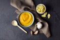 Autumn pumpkin soup in a bowl with spoon with fresh garlic and wheat croutons on dark grunge background. Royalty Free Stock Photo