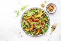 Autumn pumpkin salad with baked honey pumpkin slices, lettuce, arugula, pomegranate seeds and walnuts. Healthy vegan eating, Royalty Free Stock Photo