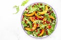 Autumn pumpkin salad with baked honey pumpkin slices, lettuce, arugula, pomegranate seeds and walnuts. Healthy vegan eating, Royalty Free Stock Photo