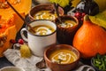 Autumn pumpkin soup puree with cream in cups, the autumn scenery Royalty Free Stock Photo