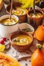 Autumn pumpkin soup puree with cream in cups, the autumn scenery Royalty Free Stock Photo