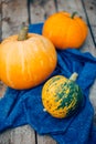 Autumn Pumpkin Thanksgiving Background - orange pumpkins over wooden table. Mottled orange-green pumpkin, closeup,