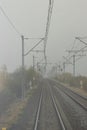 Autumn railway tracks and traffic signals in a foggy morning. View from the last car of the train. Tourism concept. Royalty Free Stock Photo