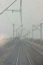 Autumn railway tracks and traffic signals in a foggy morning. View from the last car of the train. Tourism concept. Royalty Free Stock Photo