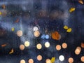 Autumn rain and leaves bokeh light  in City evening blurred street reflection modern buildings  urban architecture, cold season Royalty Free Stock Photo