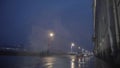 Autumn rainy city street at night, night traffic on wet road during rain, street lights reflected in puddles. Motion