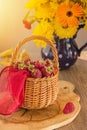 Autumn. Raspberry in a basket and a bouquet of yellow flowers. Royalty Free Stock Photo