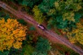 Autumn road in forest, concept of trip by red car aerial top view Royalty Free Stock Photo