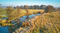 Autumn rural landscape. Frost on grass. River, green field, meadow, trees on riverbank. Dirt road on grassland Royalty Free Stock Photo