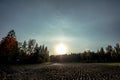 Autumn, rural landscape, plowed field and forest edge, at sunset. The sun`s rays hit the lens Royalty Free Stock Photo